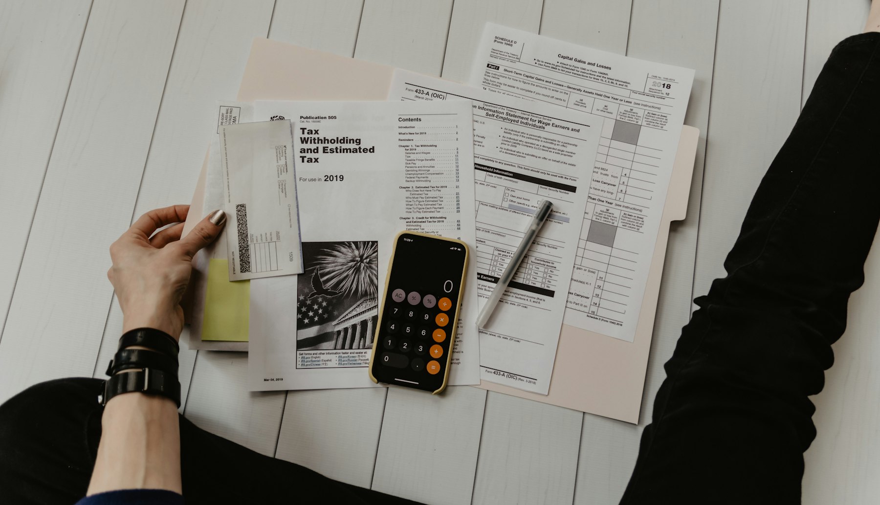Calculator, pen and financial documents on a desk