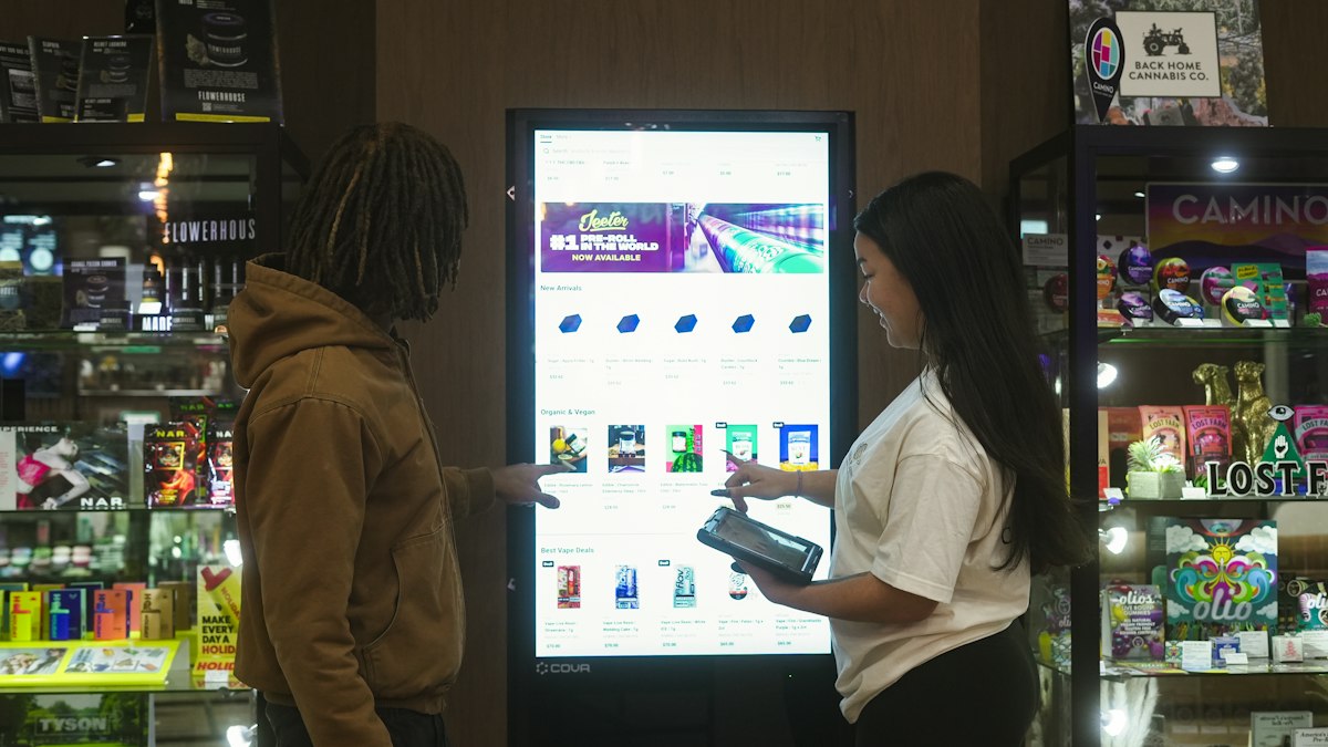 Two people using a digital display screen